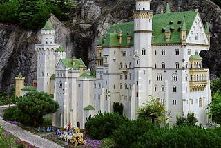 A beautifully detailed castle made out of LEGO bricks set outside in nature so that it resembles a real castle.