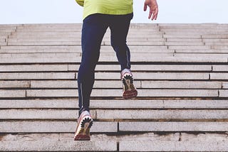 A runner running up a flight of concrete steps