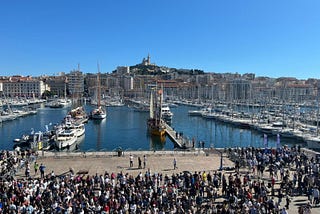 A crowd assembled at the harbor to greet the arrival of the Olympic flame.