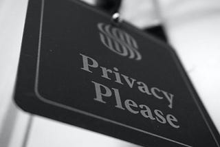 A black and white sign with privacy please written on it