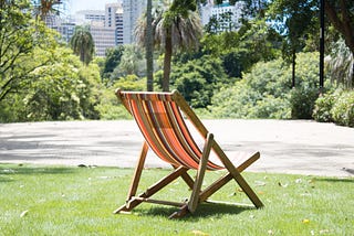 Unoccupied deckchair in an empty park in the city.