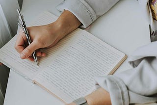 Person writing in a notebook.