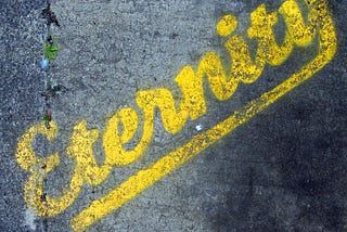 Imagen de la palabra eternidad en idioma inglés, pintada con tiza en el pavimento.