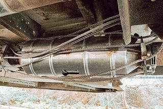 A catalytic converter surrounded by an anti-theft device made of sturdy steel cables.