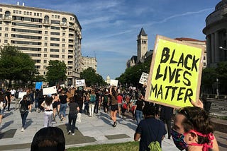 A protestor at a Black Lives Matter rally holds up a sign that reads, “Black Lives Matter.”