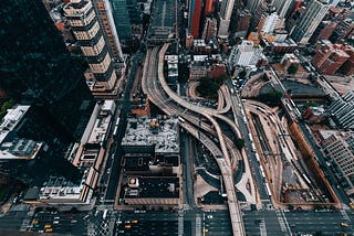 Looking straight down at large city streets and overpasses in an urban center.