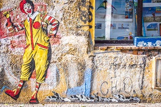 Wall of graffiti featuring Ronald McDonald, the McDonalds restaurant mascot