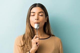 A young woman tasting spoon
