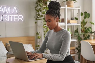 Black woman writing on a laptop — I Had to Quit These 5 Things Before I Made Money Writing