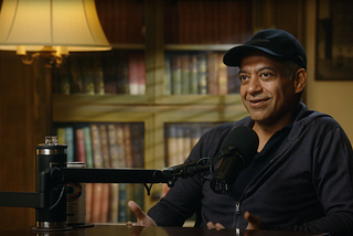 Naval Ravikant smiling during podcast interview with Modern Wisdom, sharing philosophical insights on happiness, success, and living authentically.