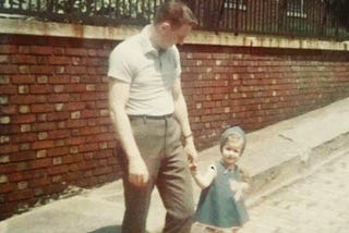 A young man walking his daughter across the street in the 1960’s Bronx