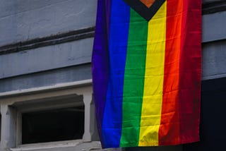 A pride flag hanging from a building