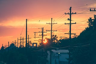 Sunset in the suburbs over power lines.