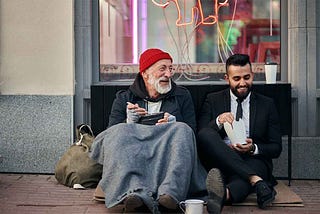 adult man sharing a meal with a homeless person