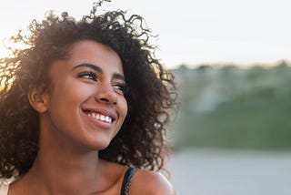 WOMEN SIDE FACING AND SMILING.