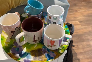 colorful coffee mugs sitting on a colorful platter