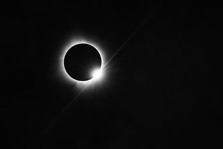 The diamond ring effect of the sun peaking out from behind the moon after moments of complete totality.