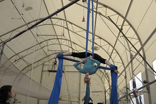 Author hanging upside down on aerial silks