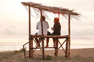 A man and a woman talking at the beach.