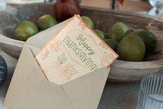 A “happy thanksgiving” card on top of a thanksgiving dinner table.