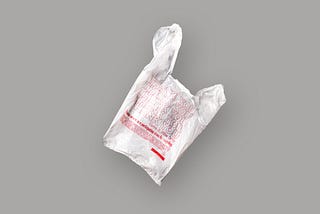 White plastic grocery bag with red “thank you” text on gray background