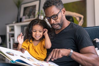 Father reading to his daughter