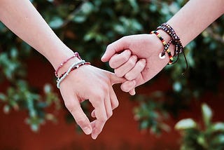 holding hands, wearing friendship bracelets