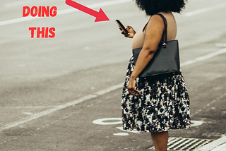 Woman in crosswalk looking at phone, about to be killed or cause an accident