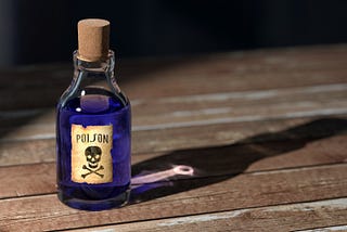 A bottle with blue liquid inside it and a label that says poison.