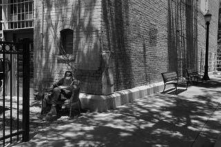 Grand Junction resident Warren Barnes, aka “the reading man” sits alone reading a book in an alley off Main Street in downtown Grand Junction on June 24, 2018. (William Woody, Special to The Colorado Sun)