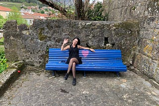 Young woman in a beautiful blue park bench with a pink heart, in Melgaço — Portugal