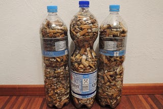 Picture of 3 plastic bottles, filled with cigarette butts