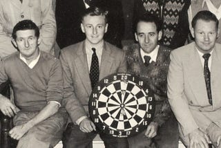 An old time picture of a dart throwing team.