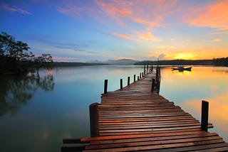 Jetty on a calm lake with a beautiful sunrise
