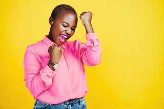 “I just keep winning” is a photo of a woman wearing a pink shirt and bold pink lipstick by Delmaine Donson via Canva Teams.