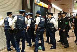 A group of Japanese police subduing a suspect