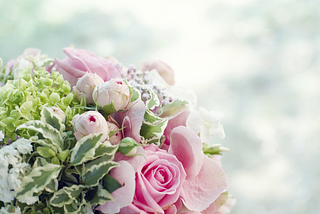 Flower bouquet with light pink roses and green foliage.