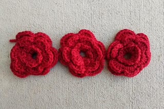 Three red crochet flowers