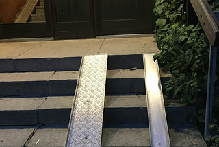 ramp installed besides a small staircase at the gateway of an apartment building