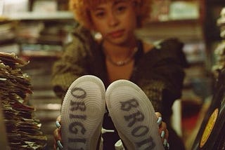 Rapper Ice Spice sitting on with her shoes on the counter.