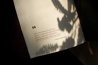 Pada gambar ini ada buku yang bertuliskan: Pada abad kedua puluh ‘saya berpikir maka saya ada’ tidak lagi berlaku, melainkan ‘orang lain memikirkan saya maka saya ada’. oleh Peter Sloterdjik.