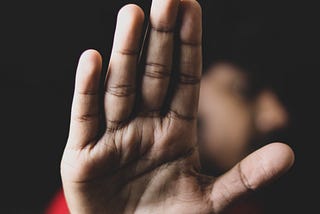 Brown man with hand to the camera