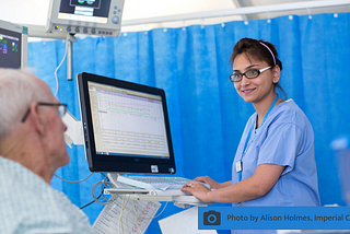 A member of the medical team on a hospital ward with a patient