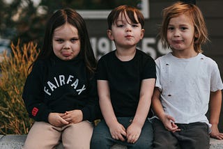 Photo of three young children making funny faces.