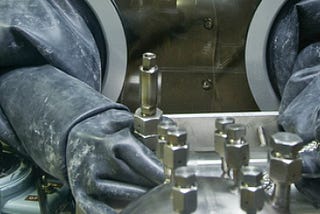 A close-up picture of a nuclear worker’s rubber gloves in a sealed facility