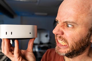 Mark Ellis holding up and baring his teeth in anger at the M4 Mac Mini