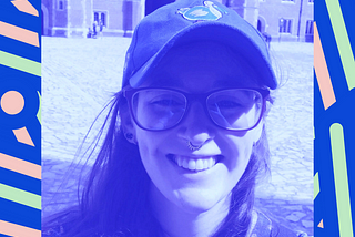 A photo of Niamh Broderick, a smiling woman wearing glasses and a cap.