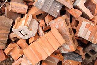 A pile of bricks, some broken and other filled with mortar.