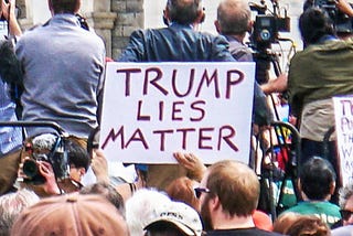 Protester Holds sign reading “Trump Lies Matter.”