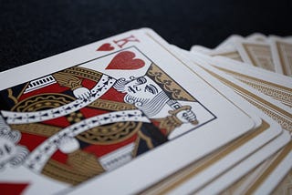 A deck of playing cards with only a King of Hearts revealed facing up on top.